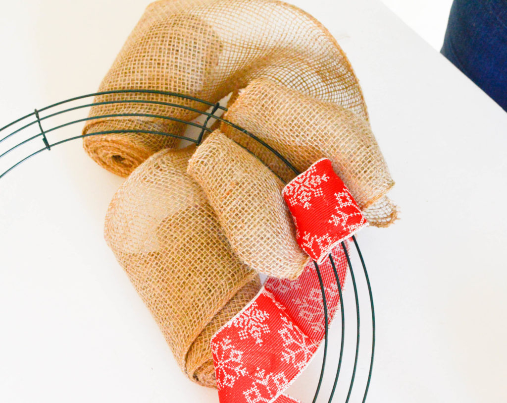 This Christmas burlap wreath is the perfect way to add some rustic charm to your home for the holiday season! It screams Farmhouse and is super budget-friendly! Pop over to get all of the details on how to make one yourself!