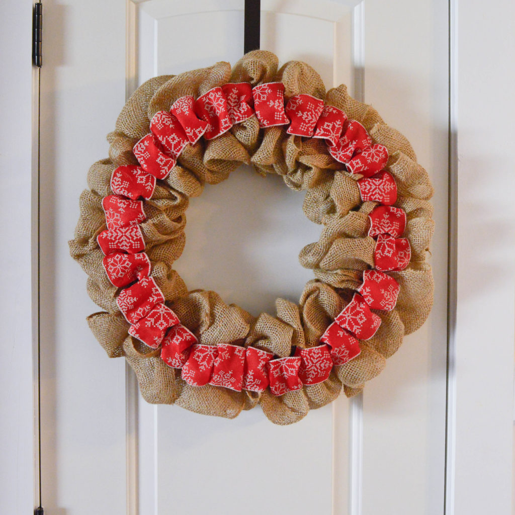 This Christmas burlap wreath is the perfect way to add some rustic charm to your home for the holiday season! It screams Farmhouse and is super budget-friendly! Pop over to get all of the details on how to make one yourself!